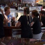 4 staff members standing at bar with bartender